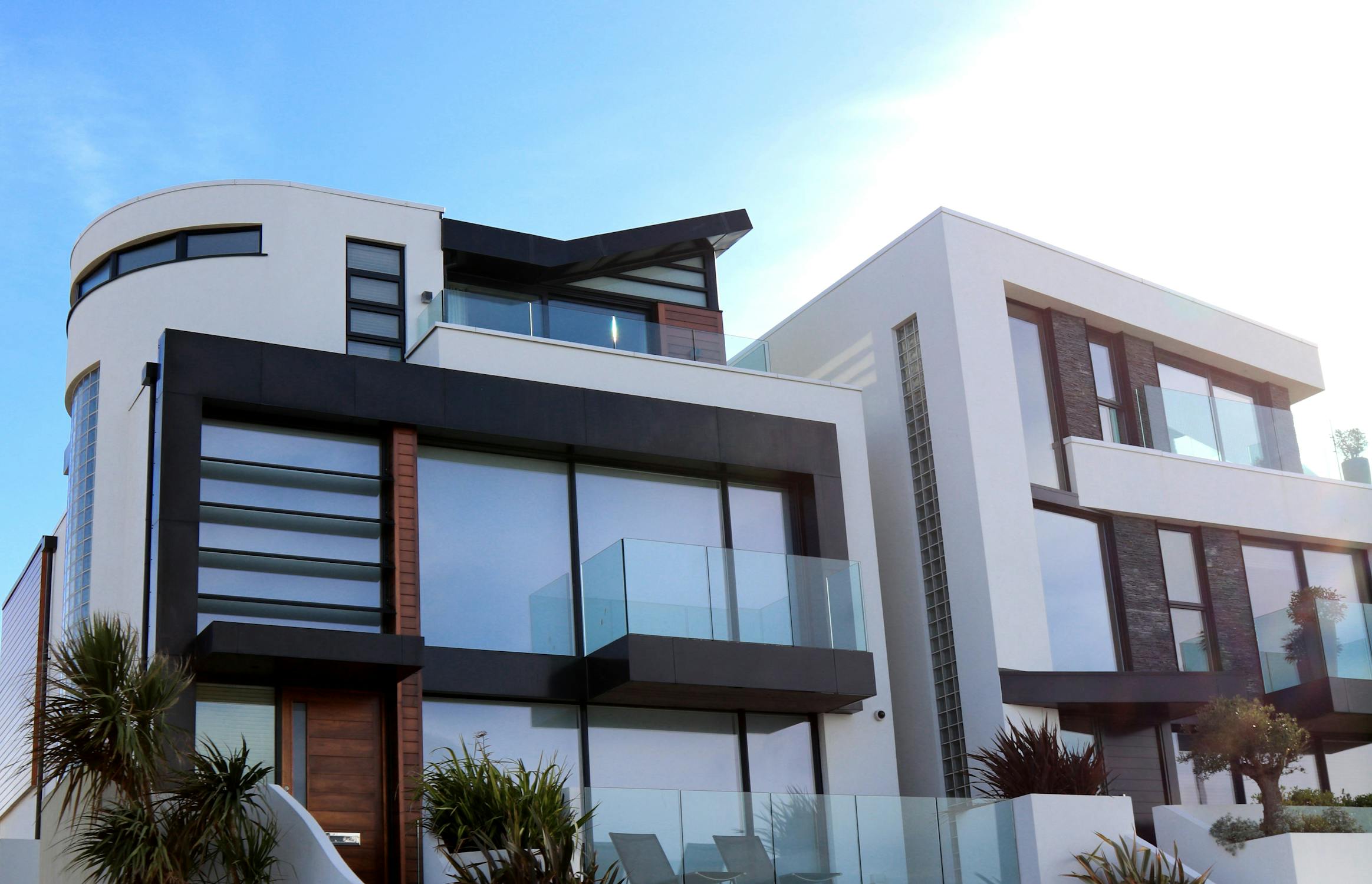 hyper-realistic wide shot looking up at modern jet black glass architecture with yellow accent reflections, clean sky, architectural rendering style, no people, minimalist